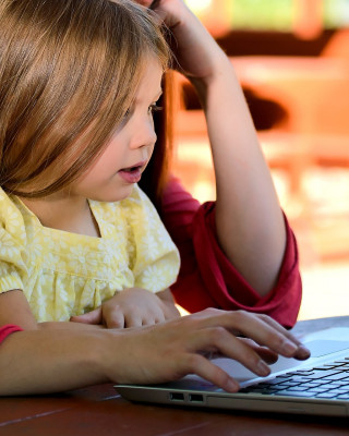 Lapsi ja vanhempi tietokoneella.